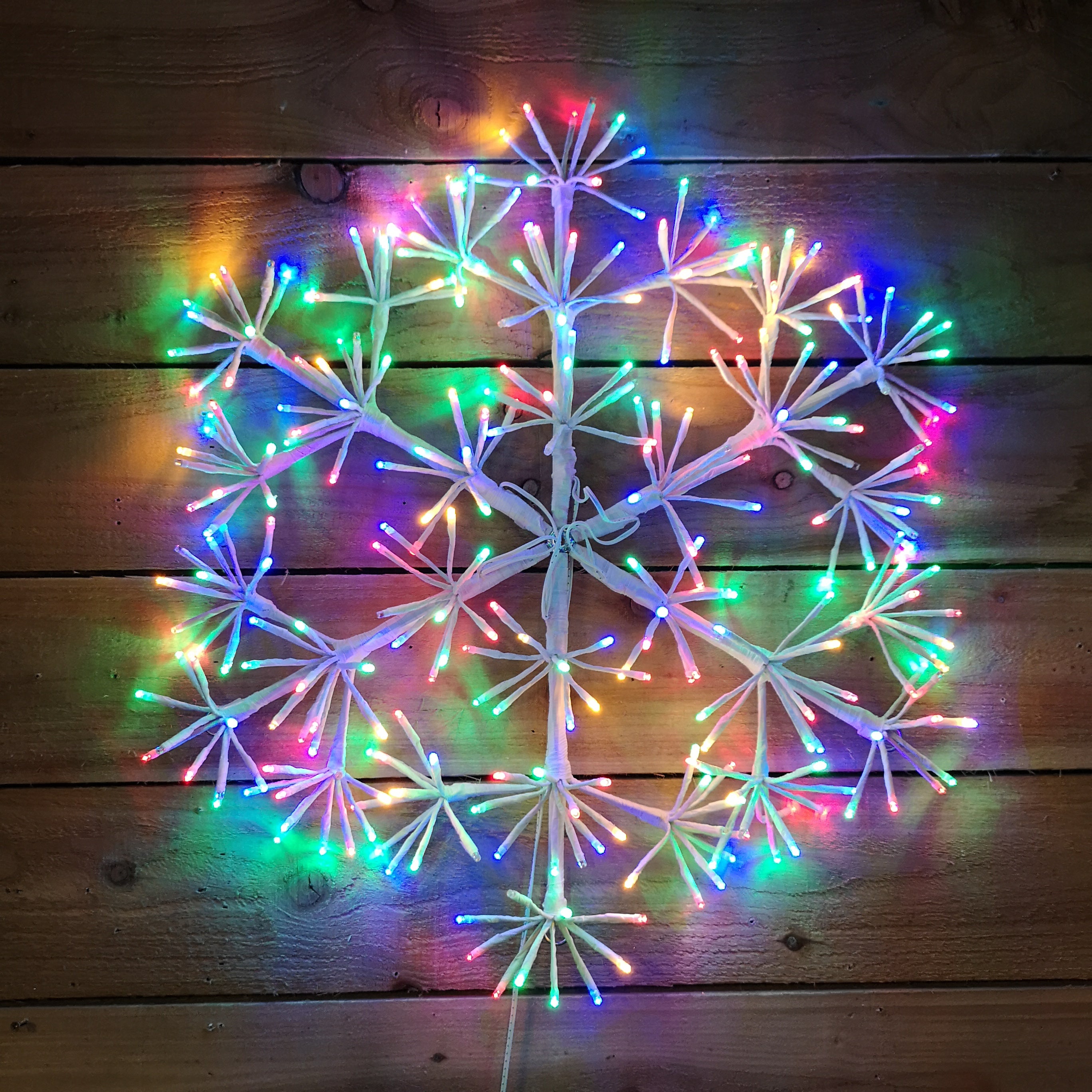 60cm Premier White Starburst Christmas Snowflake, Multi Coloured twinkling lights.